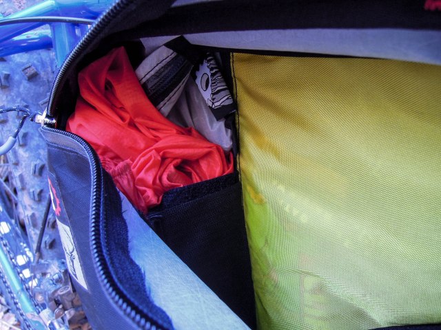 The back compartment stuffed with: spare tube, patch repair kit & other repair supplies, emergency ditty bag, and a lightweight wind jacket.