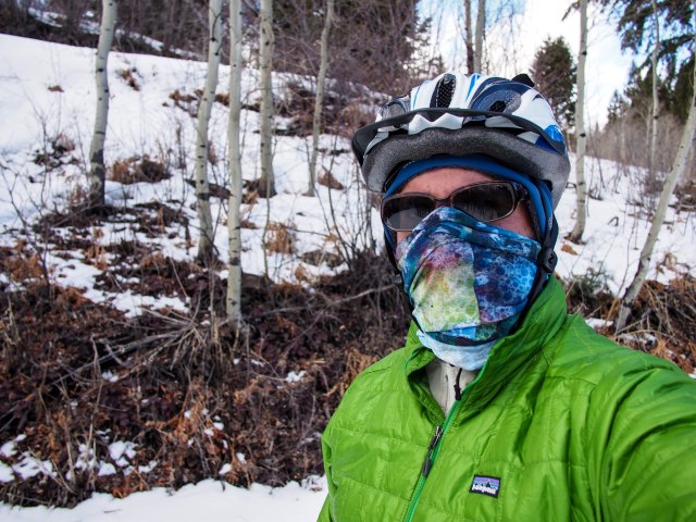 Dressed for a cold, windy day (and descending). Buff used as a face mask, softshell beanie, and puffy jacket.